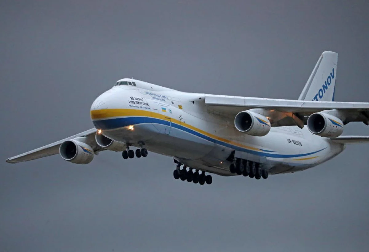 Aeronave cargueira de grande porte em voo, representando peso, massa e sustentação.